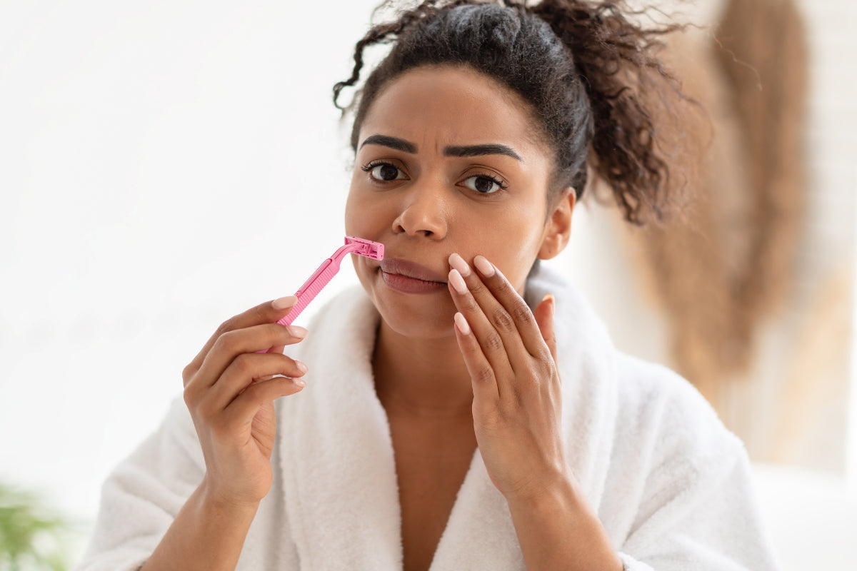 female is shaving her hair around her lips