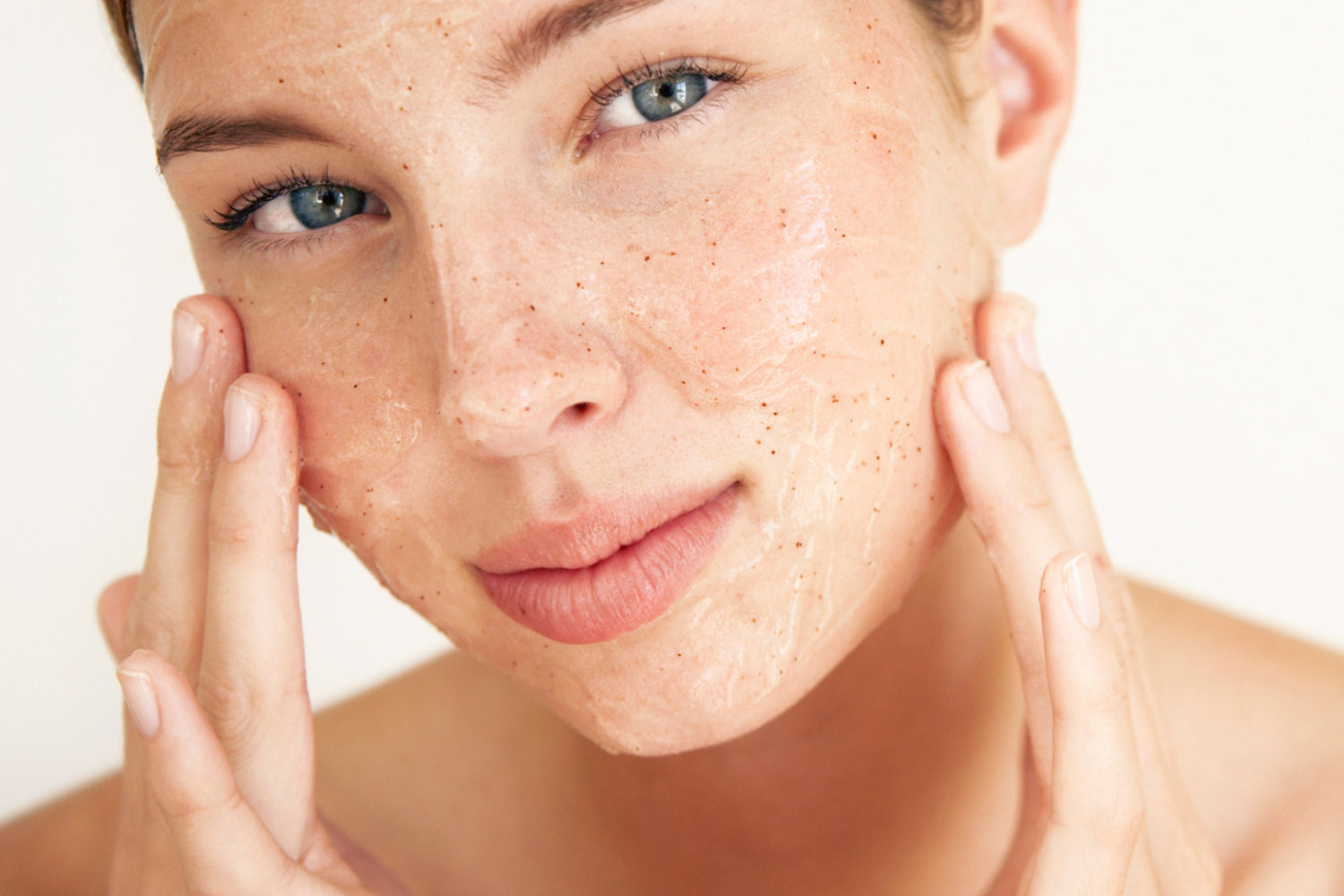 young female exfoliating her face
