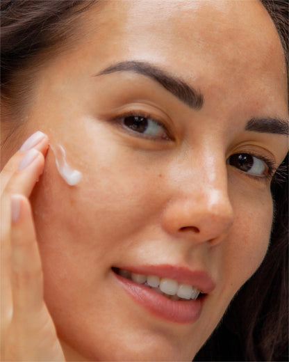 female apply water-based water treatment moisturizer on her face